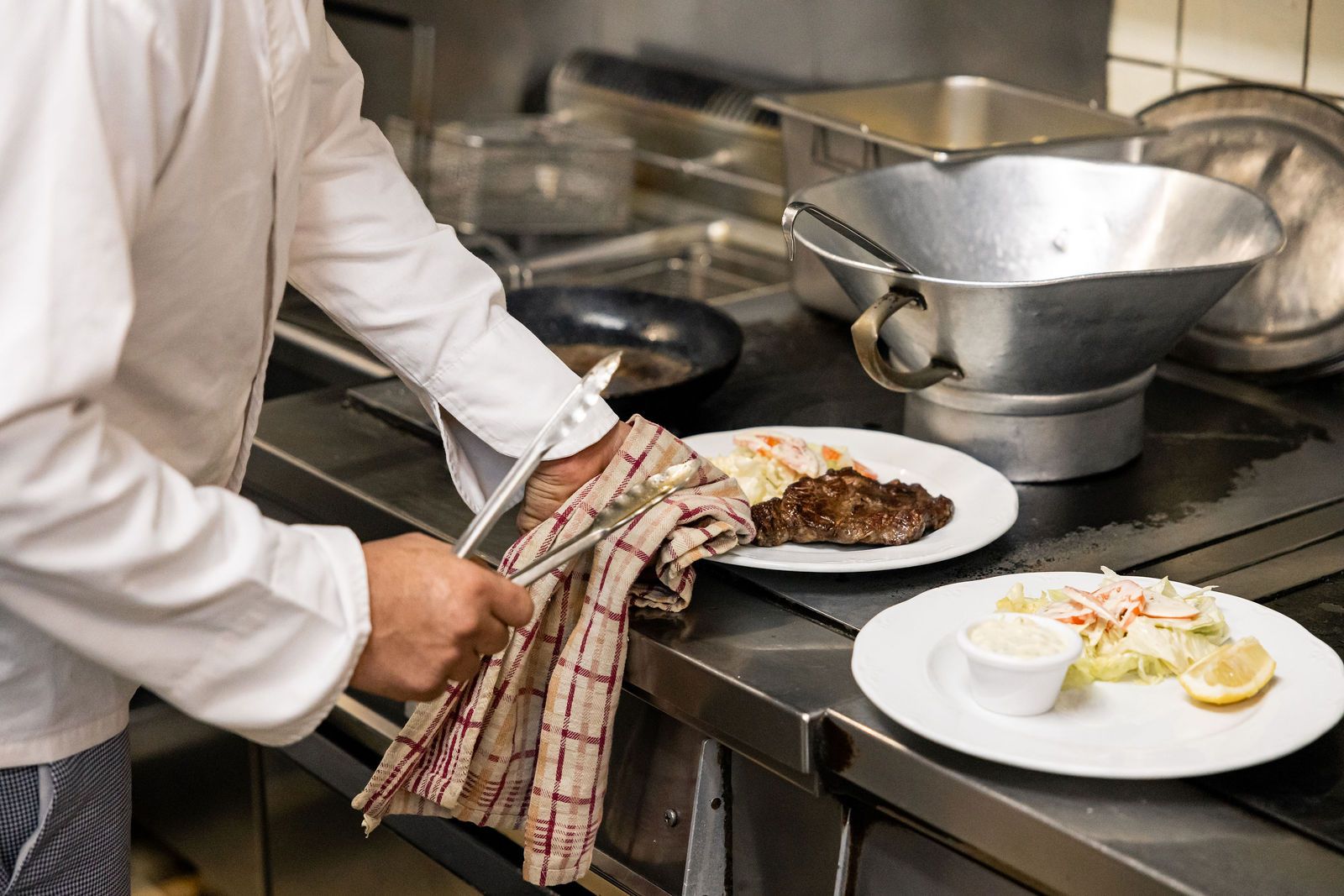 Dressage d'une pièce de viande et de sa garniture au passe de la cuisine
