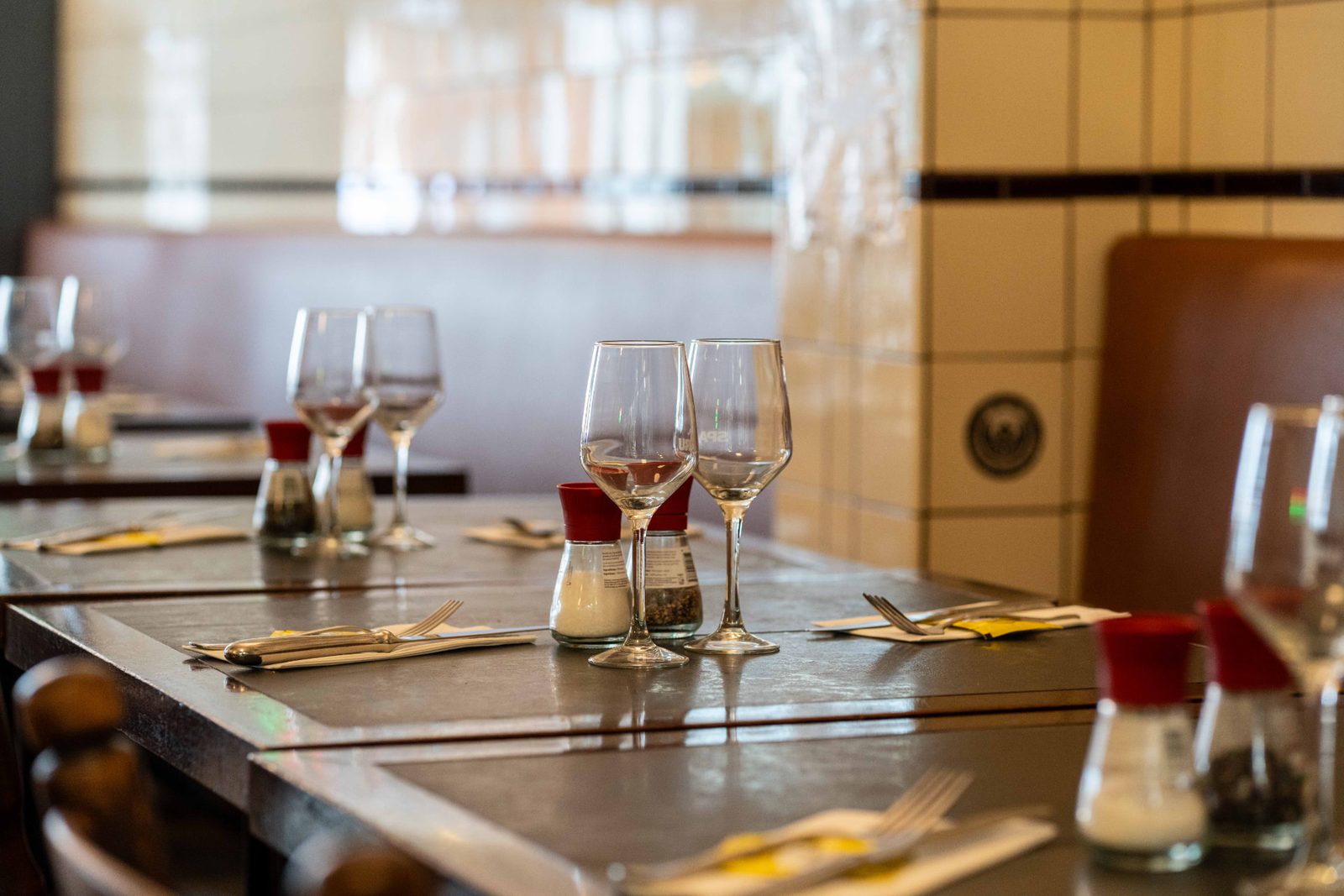 Verres de vin rosé sur une table du Pré Salé, banquette et faïence en arrière-plan